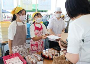 トマトを使った料理やお菓子を販売する葛塚東小の4年生=28日、新潟市北区東栄町1