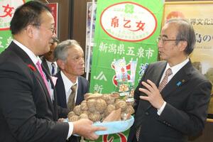 生産農家らからサトイモの株を手渡される花角英世知事=11月22日、県庁