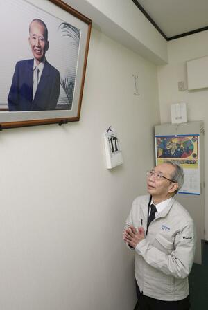 阪神大震災の発生から30年の節目に、本社・工場の復旧に奔走した父山下清さんの写真に手を合わせる清一さん=1月17日、兵庫県伊丹市(本社取材班・富山翼撮影)