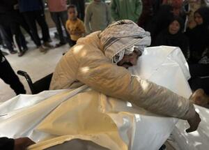 イスラエルの無人機攻撃で殺害された子どもの死を悼む人=29日、ガザ南部ハンユニス(ゲッティ=共同)