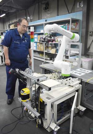 タワシテックが開発した台車移動式アームロボット。製造現場をサポートする=長岡市大荒戸町