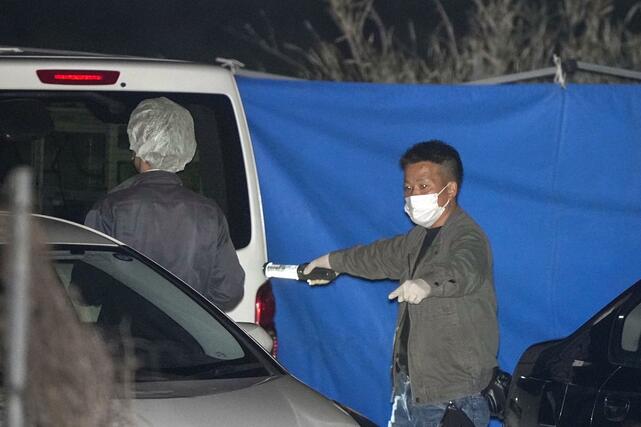 身元不明の遺体が見つかったとみられる京都府南丹市の現場付近を調べる捜査員ら＝１３日午後８時３２分