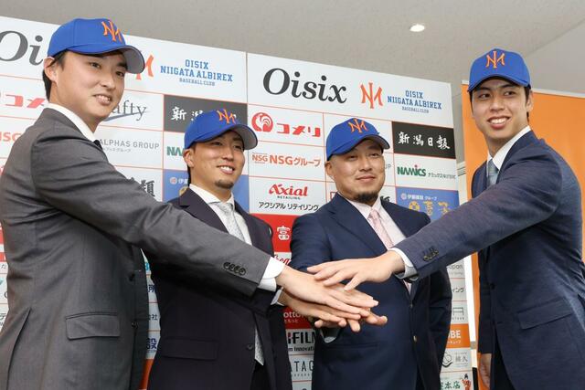 会見後、写真撮影に応じる左から石川直也投手（元日本ハム）、井口和朋投手（元オリックス）、松山竜平外野手兼打撃コーチ（元広島）、宮森智志投手（元楽天）＝１６日、新潟市中央区のエコスタ