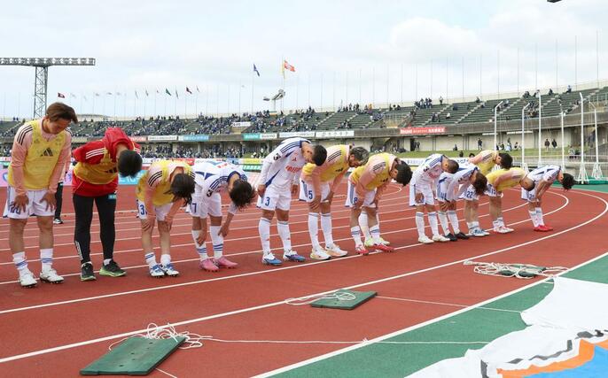 富山に敗れ、試合後、サポーターに頭を下げる新潟の選手たち＝富山県総合運動公園