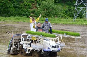 田植え機に乗り、苗を植える小林幸子さんと豊昇龍関=十日町市