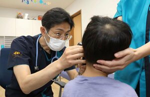 手足口病に感染した幼児を診察する大塚岳人医師