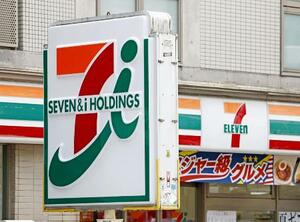 セブン&アイ・ホールディングスの看板とコンビニ店舗=7月、東京都新宿区