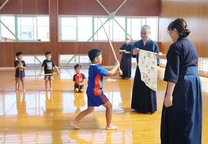 新聞紙に竹刀を力強く振り下ろす小学生=柏崎市栄町