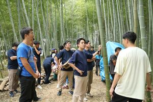 説明を受けながら、竹林を見学するツアー参加者ら=7日、田上町原ケ崎新田