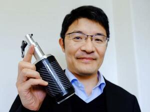 　月の地下探査に使う小型震源装置「ＰＡＳＳ」を手に、撮影に応じる辻健・東大教授＝１月、東京都文京区