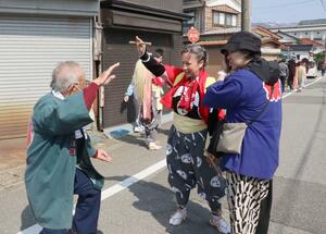 地元住民から舞についてアドバイスを受けるニコール・スタンズベリーさん(中央)。13人の海外勢が舞や太鼓などに参加し祭りを盛り上げた=佐渡市春日