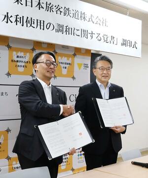 覚書に押印する十日町市の関口芳史市長(右)。左はJR東日本の喜勢陽一社長=12日、十日町市役所
