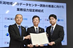 業務協力協定を締結し、写真に納まる東北電力の佐々木秀明常務執行役員(中央)ら=16日、仙台市