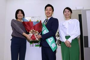 無投票再選が決まり、花束を受け取る滝沢亮氏(中央)=10月20日午後5時すぎ 三条市西裏館1