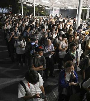 　大阪メトロ中央線が運転見合わせとなり、万博会場で運転再開を待つ大勢の人たち＝１３日深夜、大阪市此花区の夢洲