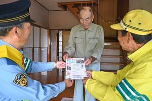 高齢者にチラシなどを配りながら、交通事故の防止を呼びかけた=5月20日、南魚沼市美佐島