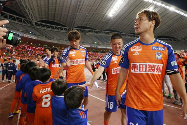 試合後サポーターに挨拶するDF堀米悠斗ら=ビッグスワン