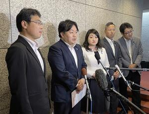 岸田文雄首相の進退にも言及した文書を自民党県連執行部に提出後、報道陣の取材に応じる青年局長の河原井拓也県議(左から2人目)ら=6月25日、県議会