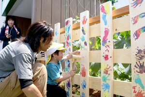 大工と同じはちまきを頭に締め、園庭の柵作りを体験した子どもたち=三条市月岡