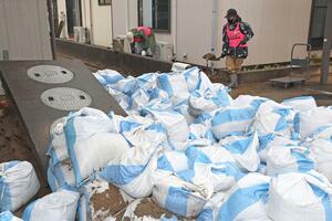 新潟市西区善久に積み上げられた土のう袋。液状化現象の影響で噴き出してきたとみられる=1月6日、新潟市西区善久