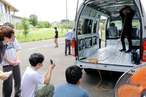 キャンピングカー製作の作業を見学する三条市立大の学生ら=三条市上須頃