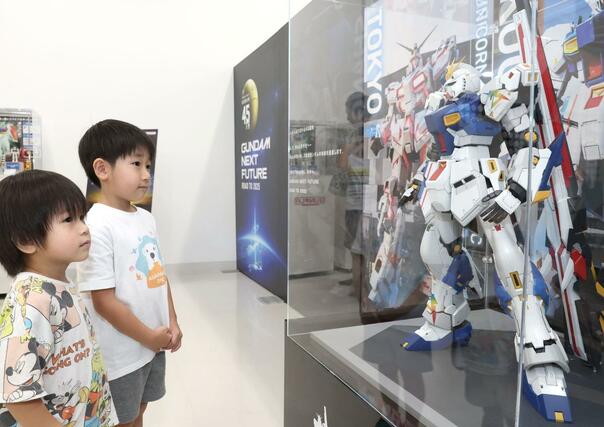 年代、性別を問わず多くのガンダムファンが訪れ、記念撮影などを楽しんでいた=9月14日、長岡市喜多町
