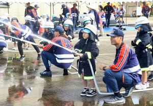 「幼年消防ふれあい広場」で放水体験をする園児=新発田市本町4