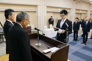 入学生を代表してあいさつする志賀義明さん(中央)=長岡市