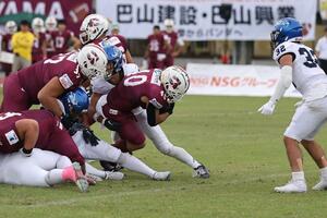 胎内ディアーズ-ブルーサンダース 第3クオーター 胎内の千代修平(中央)がタッチダウンを決める=胎内市総合グラウンド陸上競技場