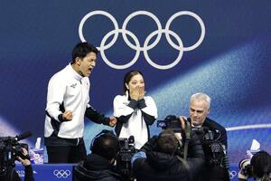 フィギュアスケートペア・フリーの得点を確認し、喜びを爆発させる三浦璃来(中央)、木原龍一組。右はブルーノ・マルコット・コーチ=16日、イタリア・ミラノ(共同)