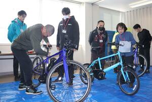 パンクしたタイヤの修理方法や点検方法を学ぶ参加者＝佐渡市相川二町目浜町