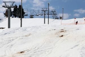 雪解けで土が露出し一部滑走ができない小出スキー場。スタッフはコース整備に力を尽くす=2月14日、魚沼市
