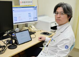 声を録音しておくためのマイクと専用アプリを搭載したタブレット端末の使い方を説明する西尾直樹准教授＝名古屋市の名古屋大病院