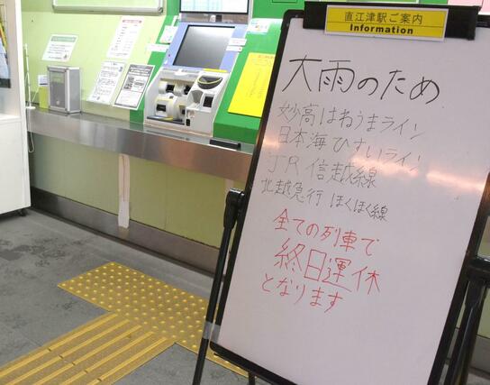 大雨により変電所が浸水したため、直江津発着の全ての列車が運休となったことを告げる看板=3日、上越市の直江津駅