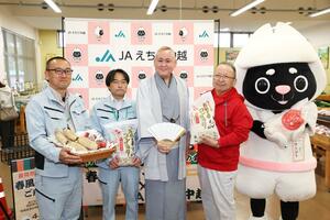ＪＡえちご中越から農産物の寄贈を受け、笑顔を見せる春風亭鯉づむさん＝２７日、長岡市関原町１