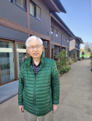 駅西住宅の前に立つ浜田昌良さん=福島県双葉町