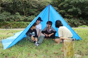 ブルーシートやロープなどを使って、シェルターを作る参加者=阿賀野市畑江