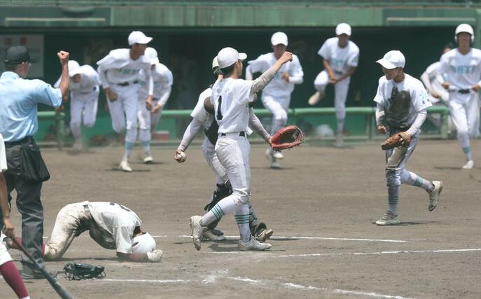 長岡向陵－長岡大手　９回表２死一、三塁、長岡向陵の早川篤哉が三塁から本塁を目指すがタッチアウトとなり、試合を決め喜ぶ長岡大手の選手ら＝長岡市悠久山球場