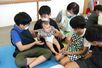 赤ちゃんと触れ合う児童たち=佐渡市千種