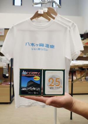 いい湯らていが開業25周年に合わせて作った特製ラベルの缶入りキャンディーとTシャツ