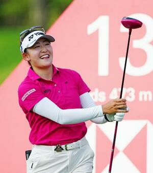 プロアマ戦でショットを放ち、笑顔を見せる岩井千怜=セントーサGC(共同)