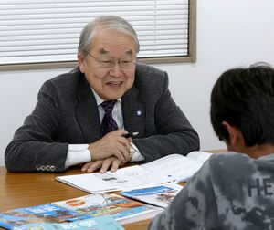 中２の生徒に数学の文章問題を教える秋山正道さん＝上越市頸城区