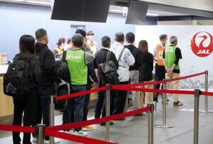 　避難計画手順確認のため、保安検査場の前で列を作る避難者役＝１８日夜、沖縄県宮古島市