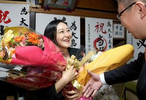 支援者から笑顔で花束を受け取る大島美香さん=4月21日、上越市本町1