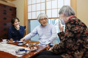 原告女性宅で、お茶会を楽しむ小谷一明さん(中央)と渡邊名南さん(左)=新潟市東区