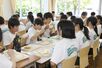 同じメニューの温かい給食を楽しむ宮浦中の生徒ら＝２５日、新潟市中央区万代５