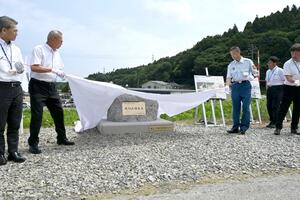 7・11水害を伝えるために建てられた姫川堤防決壊碑の除幕式=11日、糸魚川市上刈