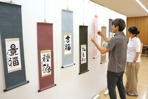 個性あふれる作品が並べられた「太陽の書展」の展示作業=21日、アオーレ長岡