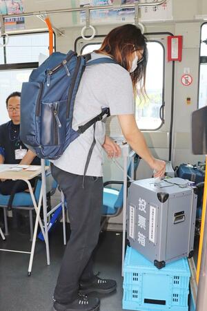 大学構内に開設された参院選の移動期日前投票所で投票する新潟工科大の学生=柏崎市藤橋