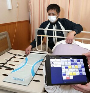 布団の下に敷き、入所者の状態を検知する機器。タブレットで確認する=長岡市渡沢町の岡南の郷